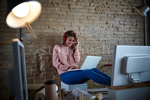 Woman hearing music headphones at office Stock photo © lunamarina