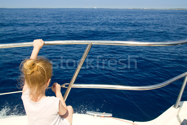 Blond little girl rear view sailing in boat Stock photo © lunamarina