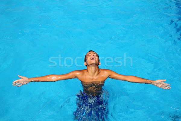 boy teenage relaxed open arms blue swimming pool Stock photo © lunamarina