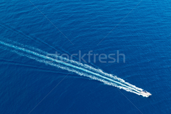 Boat surf foam aerial from prop wash in blue sea Stock photo © lunamarina