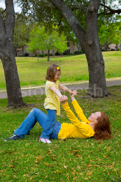 Daughter and mother playing lying on park lawn Stock photo © lunamarina