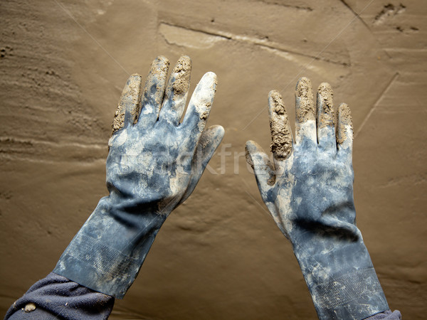 dirty grunge gloves hands on cement mortar wall Stock photo © lunamarina