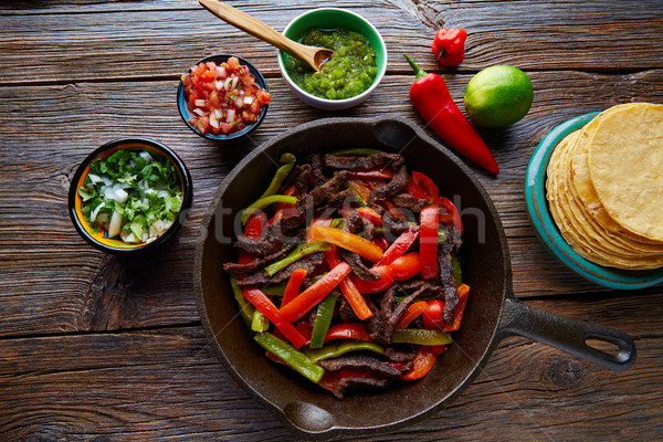 Stock photo: Beef fajitas in a pan with sauces Mexican food
