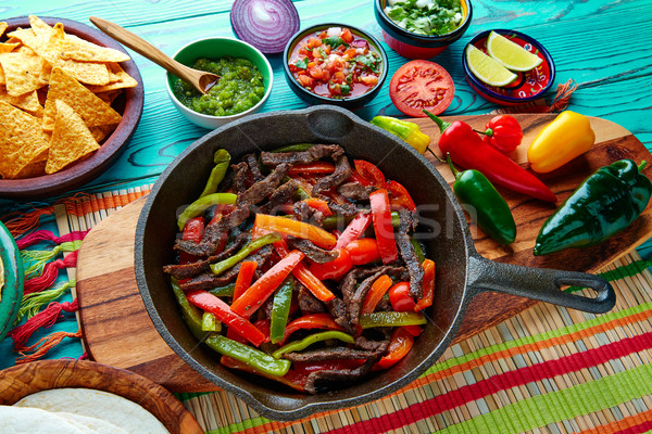Stock photo: Beef fajitas in a pan sauces chili and sides Mexican