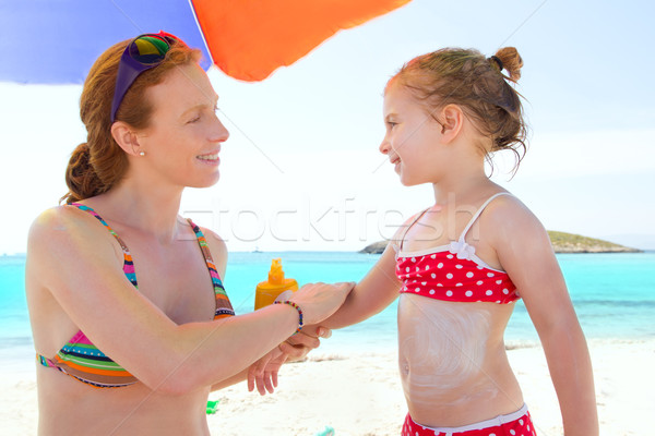 daughter and mother in beach with sunscreen Stock photo © lunamarina