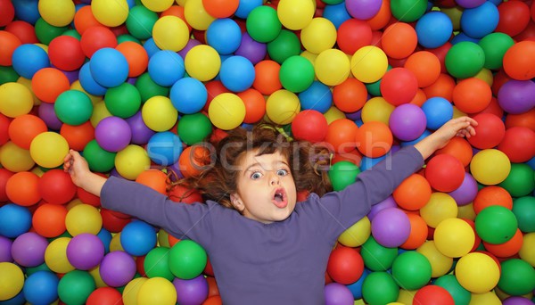 Stock photo: colorful balls funny park little girl lying gesturing