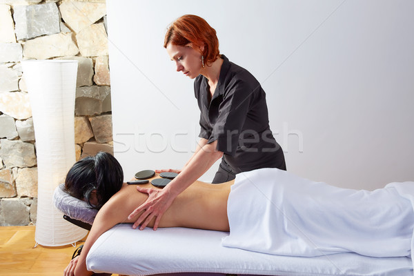 Hot stone massage in woman back physiotherapist Stock photo © lunamarina