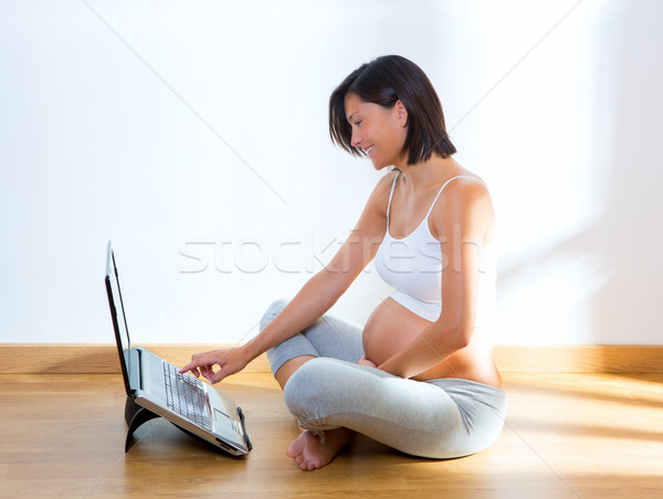 Piękna kobieta w ciąży domu laptop posiedzenia Zdjęcia stock © lunamarina