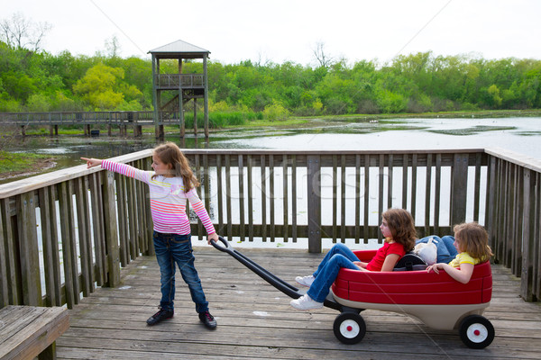 girls looking at park lake with outdoor dump cart Stock photo © lunamarina