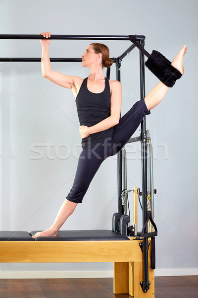 Pilates woman in cadillac split legs stretch exercise Stock photo © lunamarina
