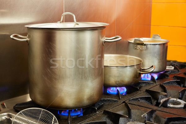 Restaurant pro kitchen with steel pans in fire Stock photo © lunamarina