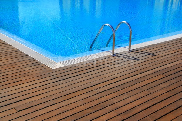 blue swimming pool with teak wood flooring Stock photo © lunamarina