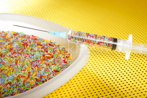 Stock photo: Little colorful candy syringe over yellow background