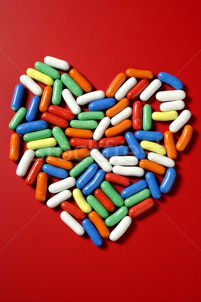 Stock photo: Colorful little candy sweets over red 