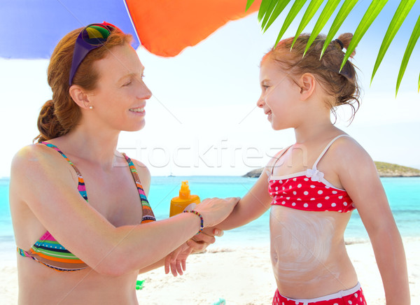 daughter and mother in beach with sunscreen Stock photo © lunamarina