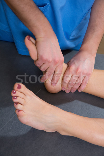 Ankle joint mobilization therapy of doctor man to woman Stock photo © lunamarina