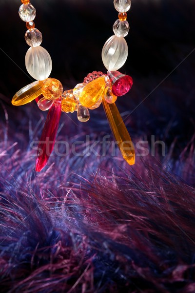 Orange jewel necklace over blue purple feather Stock photo © lunamarina