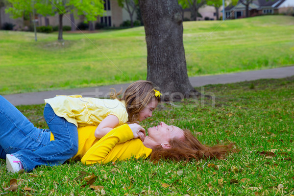 Daughter and mother playing lying on park lawn Stock photo © lunamarina