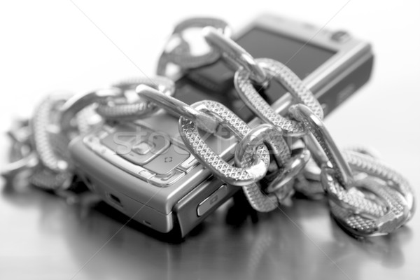 Metafora sclav telefon mobil negru alb lanţuri birou Imagine de stoc © lunamarina