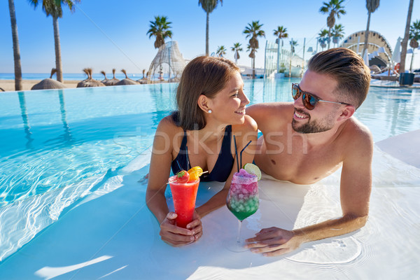 Young couple on infinity pool with cocktails Stock photo © lunamarina