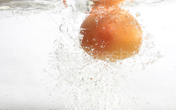 Grapefruit is falling into water. Stock photo © lypnyk2