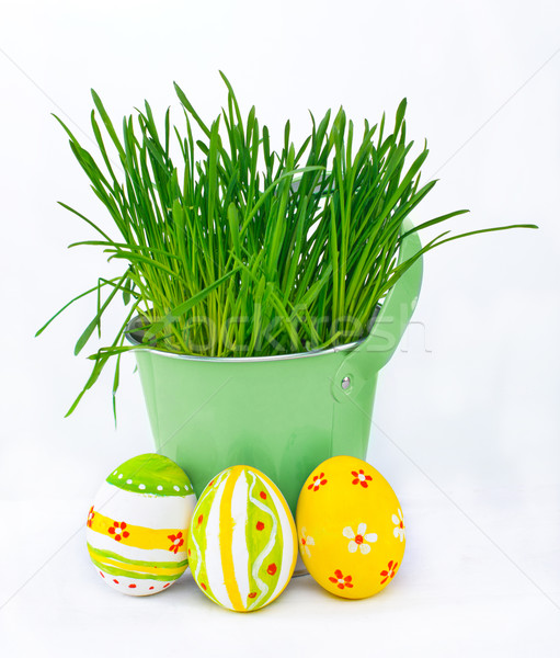 Colorful Easter eggs next to the bucket with the spring grass Stock photo © macsim