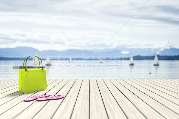 green bag on a wooden jetty with sailing boats in the background Stock photo © magann