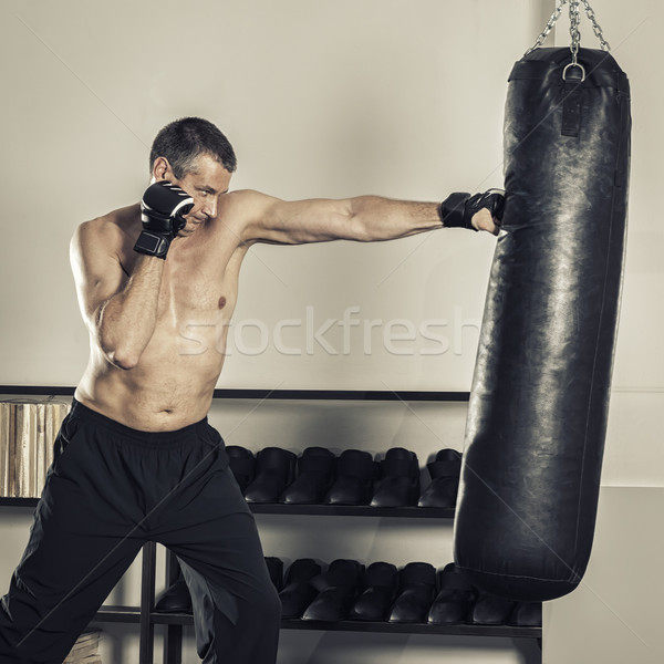 a middle age man at the punch bag Stock photo © magann