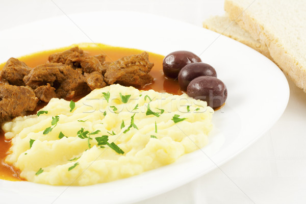 Goulash with potato puree, olives and bread Stock photo © magraphics