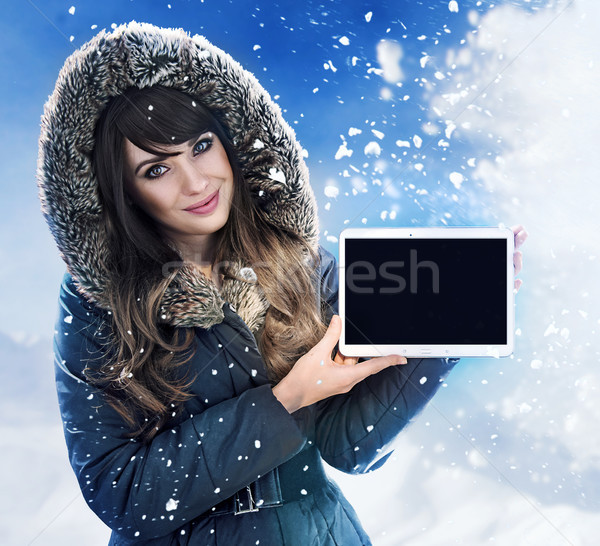 Brunette lady presenting a tablet outside - winter, chill day Stock photo © majdansky