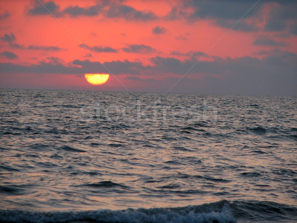 Beach sunset is a sunset sky with a wave rolling Stock photo © Mamziolzi