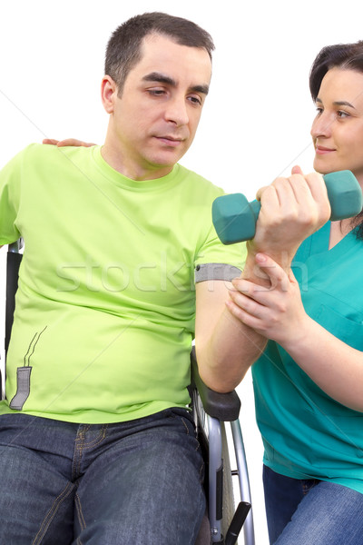 Physical therapist works with patient in lifting hands weights. Stock photo © manaemedia