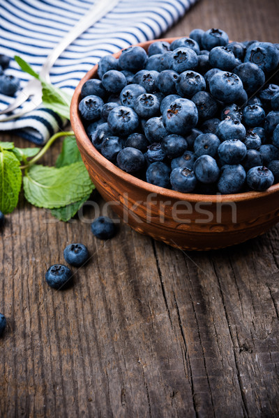 Full bowl of fresh ripe blueberries on old wooden board Stock photo © manera
