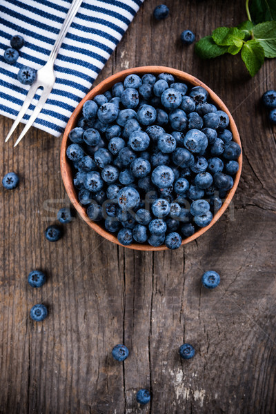 Stock photo: Full bowl of fresh ripe blueberries on old wooden board