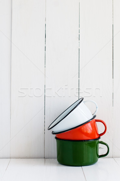 Stock photo: three bright colorful enameled mugs