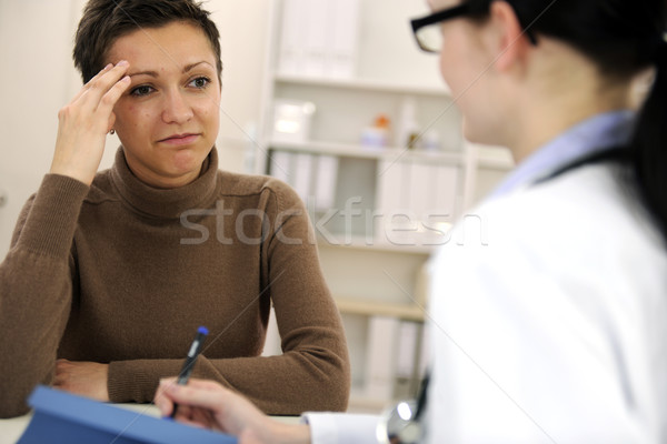 Woman suffering from migraine and doctor Stock photo © mangostock