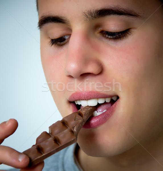 [[stock_photo]]: Adolescent · manger · chocolat · portrait · jeune · homme · visage