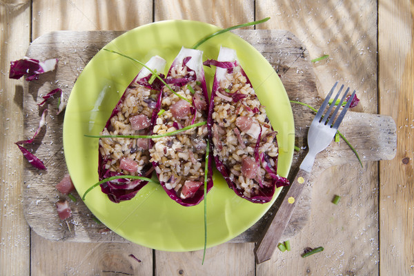 Boat of brown rice with red radicchio and speck Stock photo © marcoguidiph