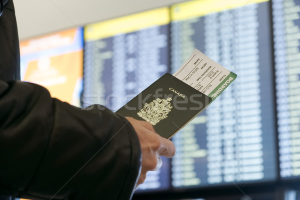 A man with a Canadian passport and boarding pass looks departure Stock photo © Margolana