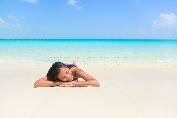 Relaxing woman on beach vacation sleeping on sand Stock photo © Maridav