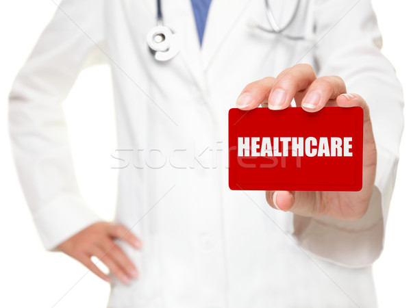 Female doctor holding HEALTHCARE card Stock photo © Maridav