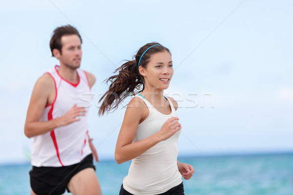 Fitness interracial runner couple running on beach Stock photo © Maridav