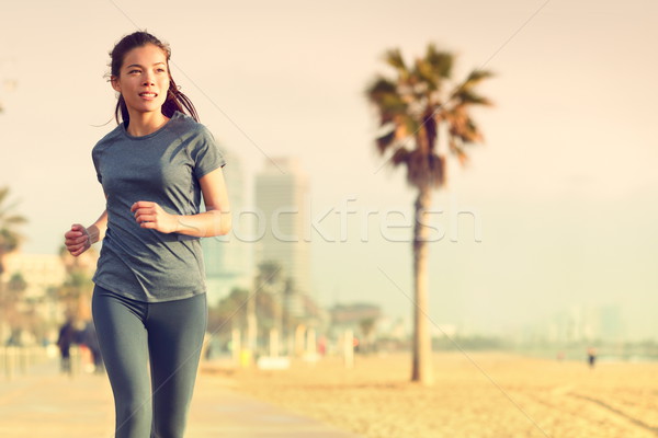 Running woman jogging on beach boardwalk Stock photo © Maridav