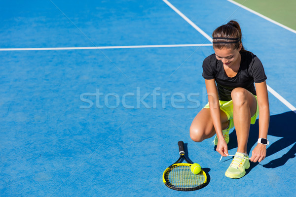Tennis player woman tying shoe laces on court Stock photo © Maridav