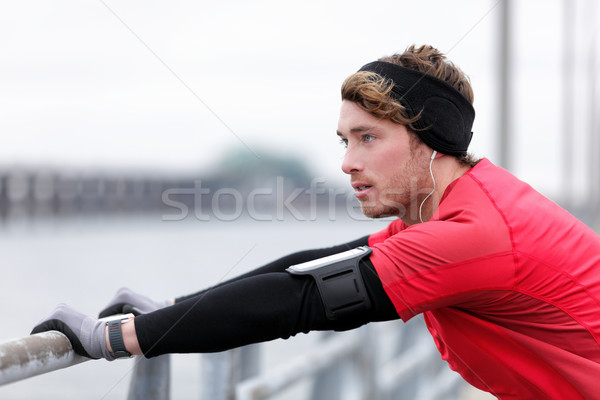 Winter runner man with smartwatch music armband Stock photo © Maridav