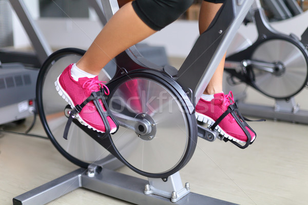 Stock photo: Exercise bike with spinning wheels - woman biking