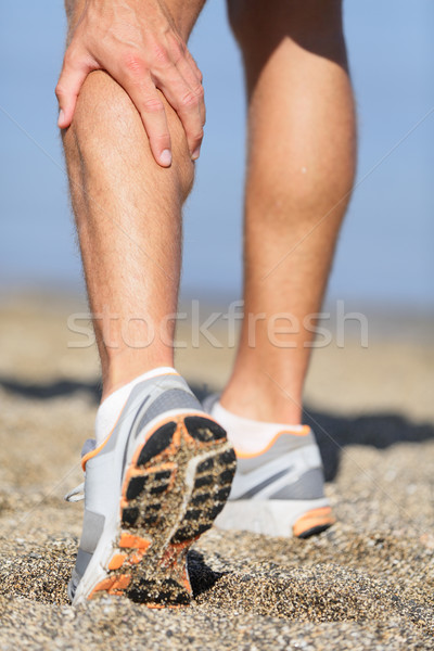 Sport injury - Man running clutching calf muscle Stock photo © Maridav