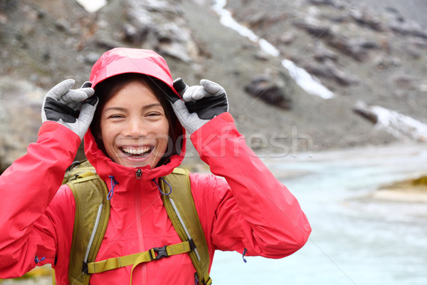 Laughing happy woman hiking with backpack in rain Stock photo © Maridav
