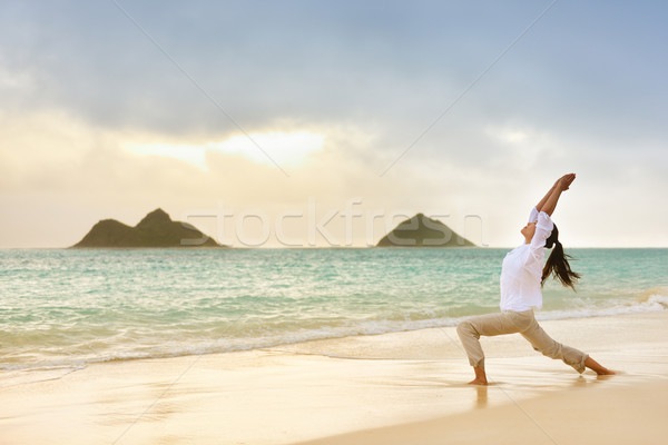 Yoga woman meditating in warrior pose at beach Stock photo © Maridav