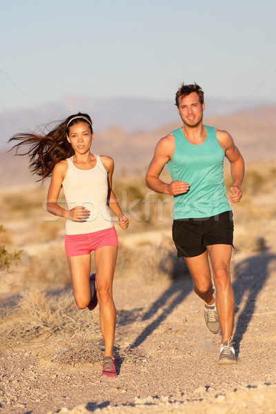 Running couple - runners jogging on trail run path Stock photo © Maridav